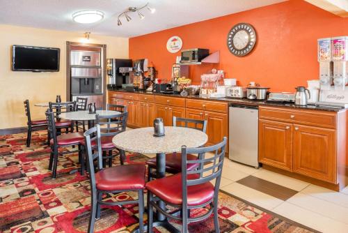 una cucina con due tavoli e una cucina con pareti arancioni di Super 8 by Wyndham Jacksonville a Jacksonville