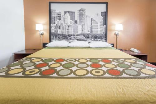a bed in a hotel room with a painting on the wall at Super 8 by Wyndham Dixon in Dixon