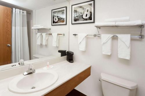 a bathroom with a sink and a toilet and a mirror at Super 8 by Wyndham Stevensville St Joseph in Stevensville