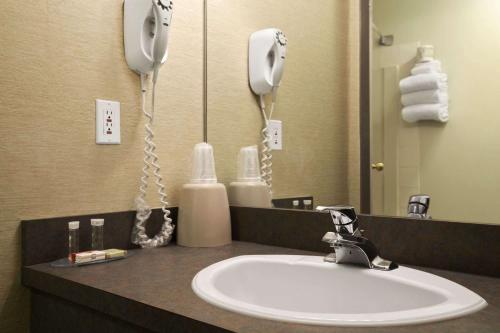 a bathroom counter with a sink and a phone at Super 8 by Wyndham Revelstoke BC in Revelstoke