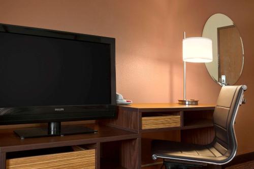 a flat screen tv sitting on a desk with a chair at Super 8 by Wyndham East Peoria in Peoria