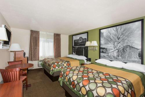 Habitación de hotel con 2 camas y mesa en Super 8 by Wyndham Perryville, en Perryville