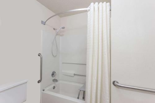 a shower with a shower curtain in a bathroom at Super 8 by Wyndham Morris in Morris