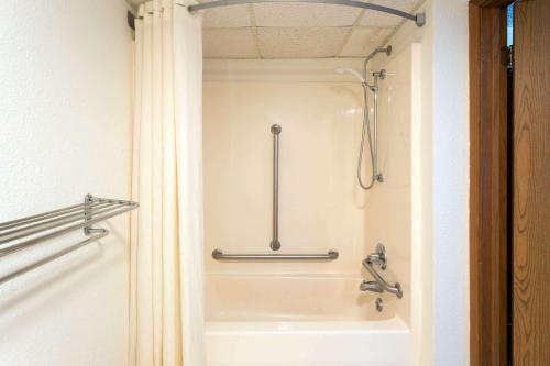 een badkamer met een douche en een bad bij Super 8 by Wyndham DeKalb IL in DeKalb