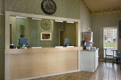 a reception desk with a clock on the wall at Super 8 by Wyndham Mount Vernon, IL in Mount Vernon