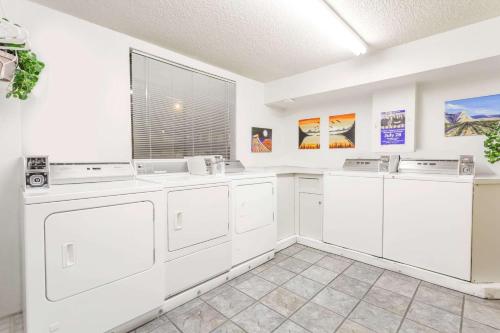 a kitchen with white appliances and a window at Super 8 by Wyndham Grand Junction Colorado in Grand Junction