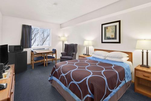 um quarto de hotel com uma cama e uma secretária em Super 8 by Wyndham Swift Current em Swift Current