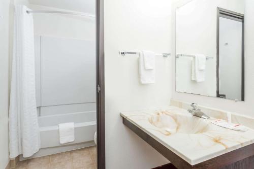 a bathroom with a sink and a mirror at Super 8 by Wyndham Grand Junction Colorado in Grand Junction