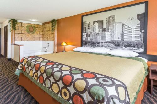 a hotel room with a bed with a large picture on the wall at Super 8 by Wyndham Dixon in Dixon