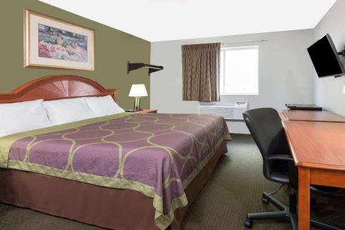 a hotel room with a bed and a desk at Super 8 by Wyndham Pittsburgh/Monroeville in Monroeville