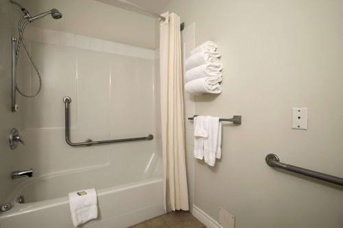 a bathroom with a shower and a bath tub with towels at Super 8 by Wyndham Revelstoke BC in Revelstoke