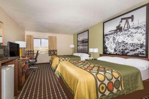 a hotel room with two beds and a flat screen tv at Super 8 by Wyndham Sterling CO in Sterling