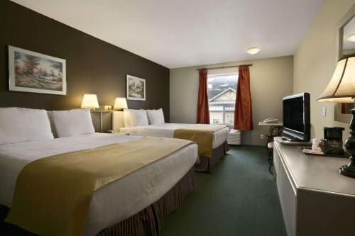 レベルストークにあるSuper 8 by Wyndham Revelstoke BCのベッド2台とテレビが備わるホテルルームです。