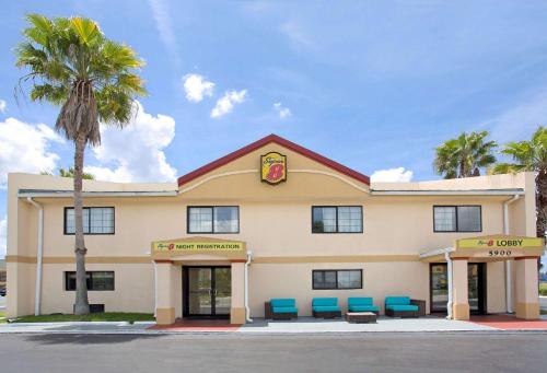 um hotel com cadeiras azuis fora dele em Super 8 by Wyndham Orlando International Drive em Orlando