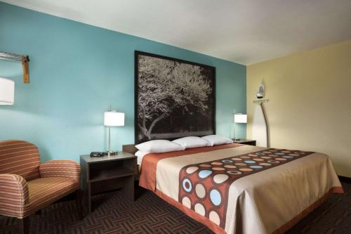 a hotel room with a bed and a chair at Super 8 by Wyndham Mount Vernon, IL in Mount Vernon