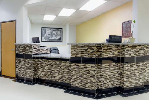 - un hall avec une réception dotée d'un mur en briques dans l'établissement Super 8 by Wyndham Klamath Falls, à Klamath Falls