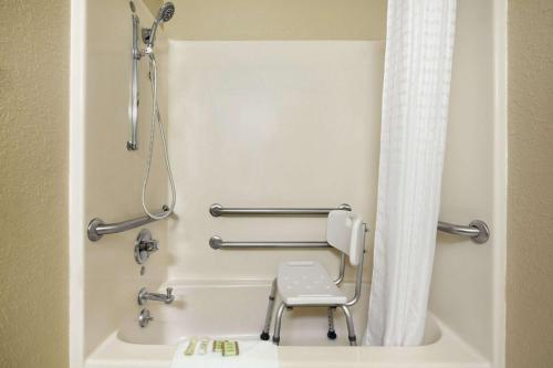 a bathroom with a shower and a toilet in a room at Super 8 by Wyndham Fairview Heights-St. Louis in Fairview Heights
