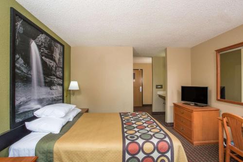 a hotel room with a bed and a flat screen tv at Super 8 by Wyndham Mendota in Mendota
