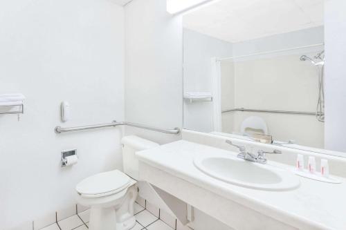 a white bathroom with a toilet and a sink at Super 8 by Wyndham Conway in Conway