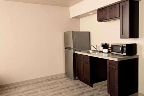 a kitchen with a stainless steel refrigerator and a sink at Super 8 by Wyndham Juneau in Juneau