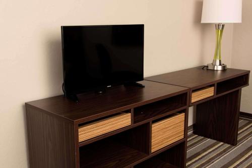 a flat screen tv sitting on top of a wooden entertainment center at Super 8 by Wyndham Juneau in Juneau