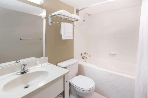 a white bathroom with a toilet and a sink at Super 8 by Wyndham Harrison AR in Harrison