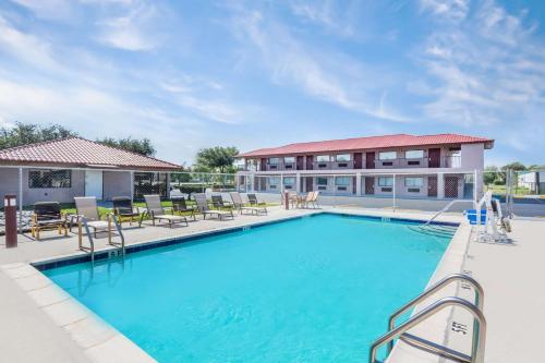a large swimming pool with chairs and a building at Redfinn Inn in Fort Pierce