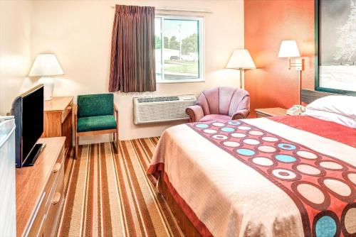 Blair的住宿－布萊爾速8酒店，酒店客房配有一张床、一张桌子和一把椅子。