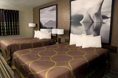 a hotel room with two beds and a painting on the wall at Super 8 by Wyndham Juneau in Juneau