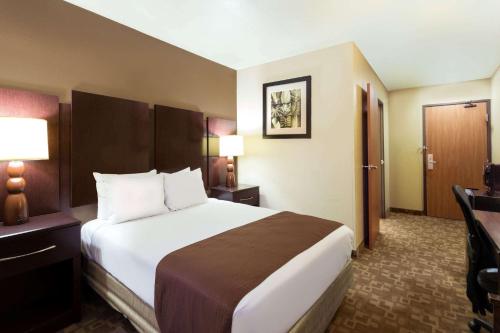 a hotel room with a large bed and a desk at Super 8 by Wyndham Chandler Phoenix in Chandler