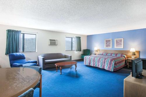 a hotel room with a bed and a living room at Super 8 by Wyndham Hot Springs in Hot Springs