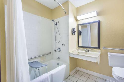 y baño con bañera, lavabo y aseo. en Super 8 by Wyndham Texarkana AR en Texarkana