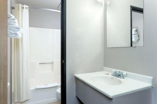 Baño blanco con lavabo y aseo en Super 8 by Wyndham Cos/Hwy. 24 E/PAFB Area en Cimarron Hills