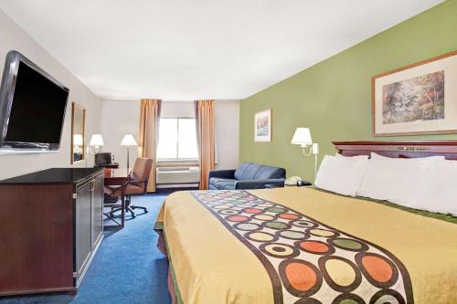 a hotel room with a bed and a flat screen tv at Super 8 by Wyndham West Memphis in West Memphis