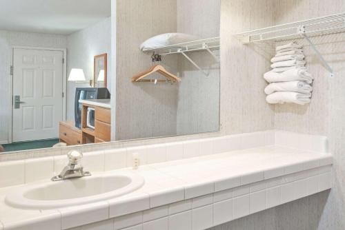 a white bathroom with a sink and a mirror at Super 8 by Wyndham Auburn in Auburn