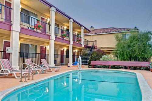 a pool in front of a hotel with chairs and a building at Super 8 by Wyndham Santa Cruz Beach Boardwalk in Santa Cruz