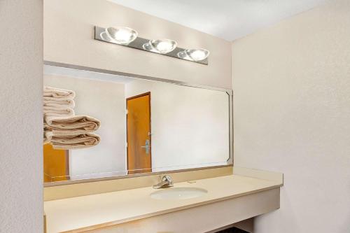 a bathroom with a sink and a large mirror at Super 8 by Wyndham West Memphis in West Memphis