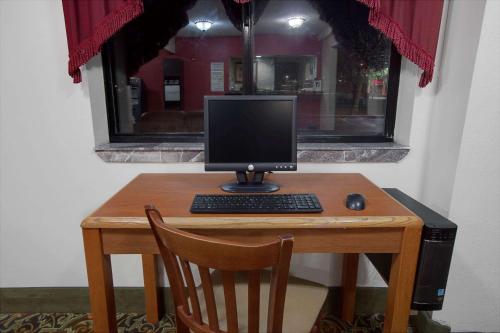 a desk with a computer monitor and a keyboard and mouse at Super 8 by Wyndham Crystal Lake in Crystal Lake