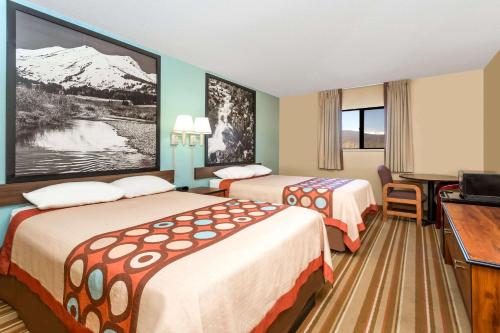 a hotel room with two beds and a flat screen tv at Super 8 by Wyndham Dillon/Breckenridge Area in Dillon
