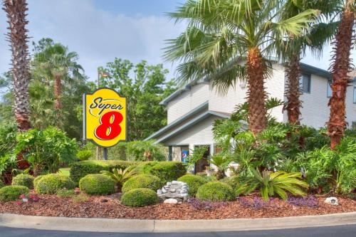 a sign for a super motel with palm trees at Super-8-Gainesville-I-75-Hospital-University-Area in Gainesville