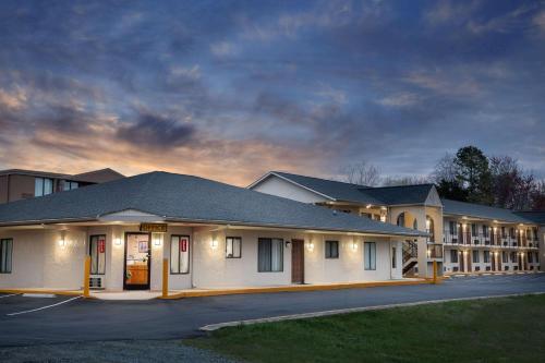 a large white building with a parking lot at Super 8 by Wyndham Burlington NC in Burlington