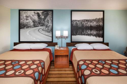 a hotel room with two beds and two pictures on the wall at Super 8 by Wyndham Burlington NC in Burlington