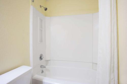 a bathroom with a shower and a white tub at Super 8 by Wyndham Warner Robins in Warner Robins