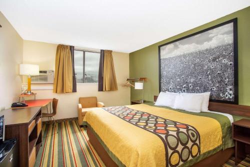 a hotel room with a bed and a desk at Super 8 by Wyndham Craig in Craig