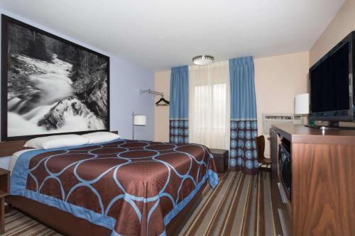 une chambre d'hôtel avec un lit et une télévision à écran plat dans l'établissement Super 8 by Wyndham Longmont/Twin Peaks, à Longmont