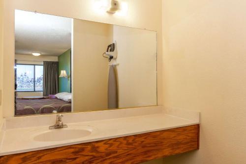 baño con lavabo y espejo grande en Mission Inn San Luis Obispo, en San Luis Obispo