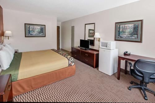 a hotel room with a bed and a desk with a computer at Super 8 by Wyndham Crystal Lake in Crystal Lake