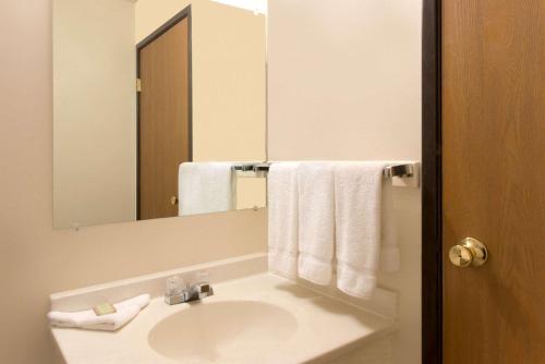 a bathroom with a sink and a mirror and towels at Super 8 by Wyndham Cortez/Mesa Verde Area in Cortez