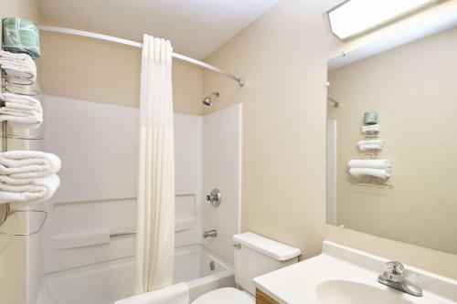 a bathroom with a sink and a toilet and a mirror at Super 8 by Wyndham Greenville in Greenville