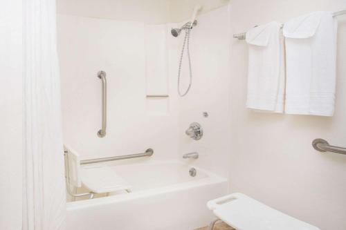 a white bathroom with a tub and a shower at Super 8 by Wyndham Limon in Limon
